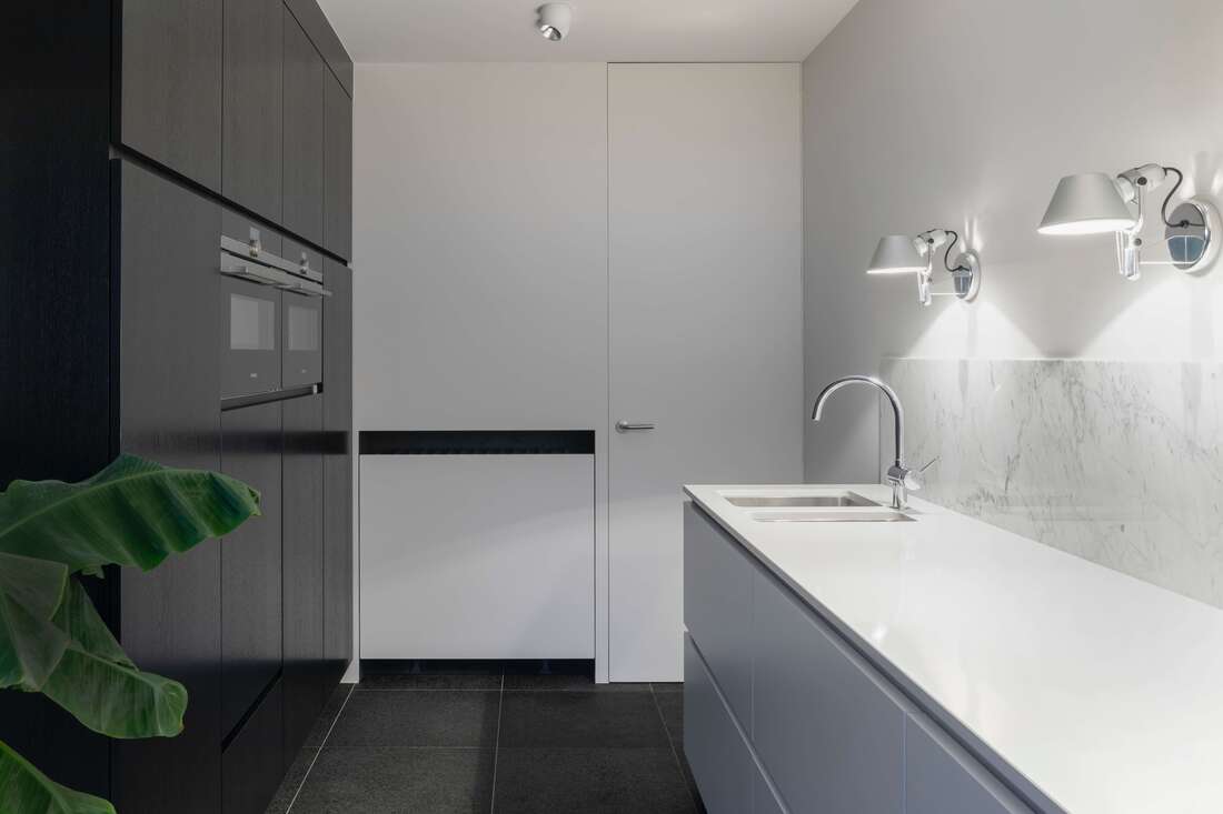 Black and gray cabinets, white quartz countertop with white backsplash and white painted walls with black tiled flooring. chrome foist and double bowl sink